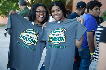 Grad students holding up We Are Mason shirts