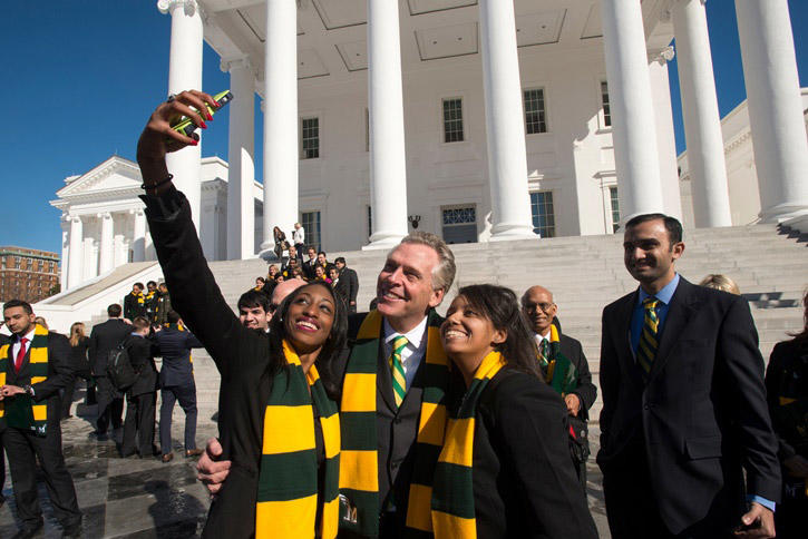 Mason students take a photo with Virginia Governor Terry McAuliffe on the steps of the Virginia State Capitol during Mason Lobbies Day in Richmond