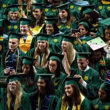 The gathering crowd of graduates takes their seats in EagleBank Arena at George Mason University's commencement exercises